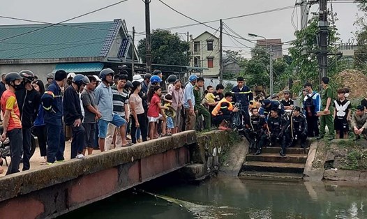 Lực lượng cứu hộ và người dân có mặt ở kênh chính hệ thống thủy lợi Nam Thạch Hãn để tìm kiếm nạn nhân nghi mất tích vì đuối nước. Ảnh: T.Vinh