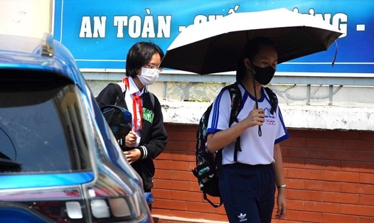 Học sinh dùng ô để tránh nắng nóng khi tan trường. Ảnh: Yến Phương
