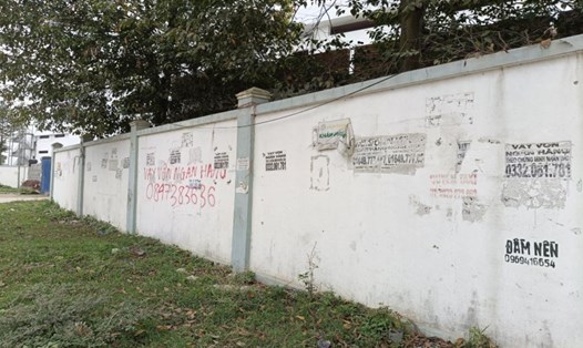 Các tờ rơi, quảng cáo cho vay tín dụng không cần thế chấp được dán chi chít trên bờ tường ở Khu công nghiệp Hoàng Long, TP Thanh Hóa. Ảnh: Quách Du
