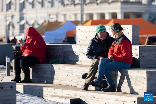 Người dân ắm nắng tại một khu chợ ở Helsinki, Phần Lan, ngày 16.3.2022. Ảnh: Xinhua