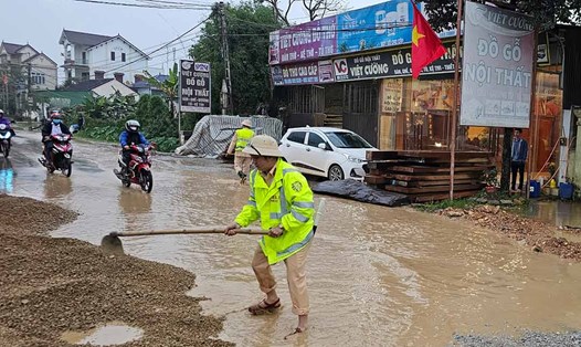 Cảnh sát giao thông Nghệ An nỗ lực khơi thông đường ngập. Ảnh: Sơn Đặng