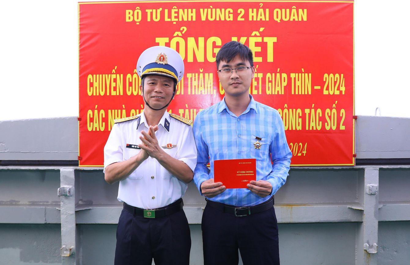 Tặng huy hiệu vì biển đảo quê hương cho các thành viên đoàn công tác.  Ảnh: Vân Trường