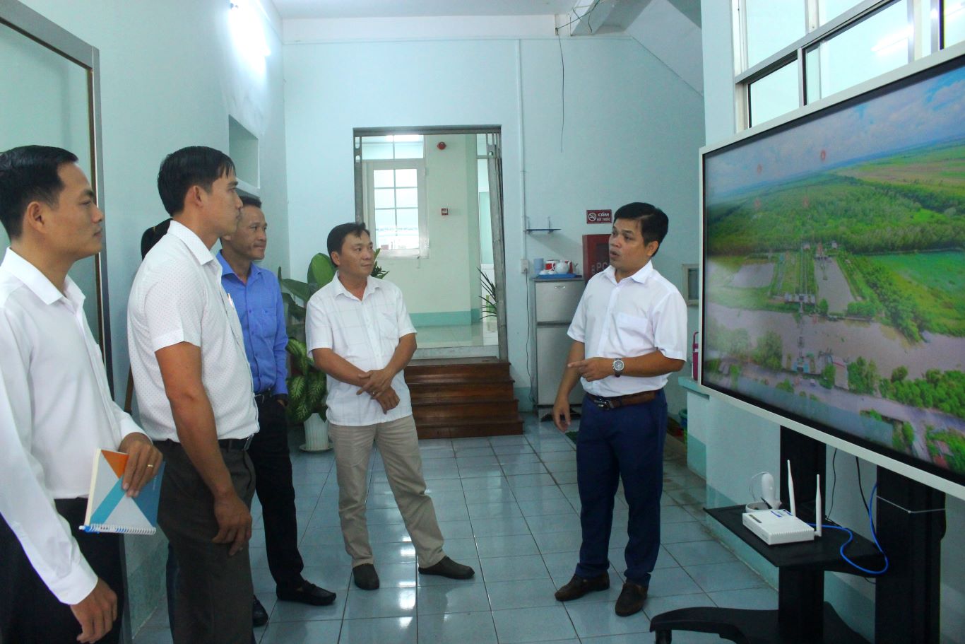 Ông Nguyễn Hữu Ngọc (bìa phải) - Phó Giám đốc Trung tâm Xúc tiến Thương mại và Đầu tư tỉnh An Giang giới thiệu với đại biểu về tiện ích của Cổng thông tin du lịch thông minh tỉnh An Giang. Ảnh: Lâm Điền