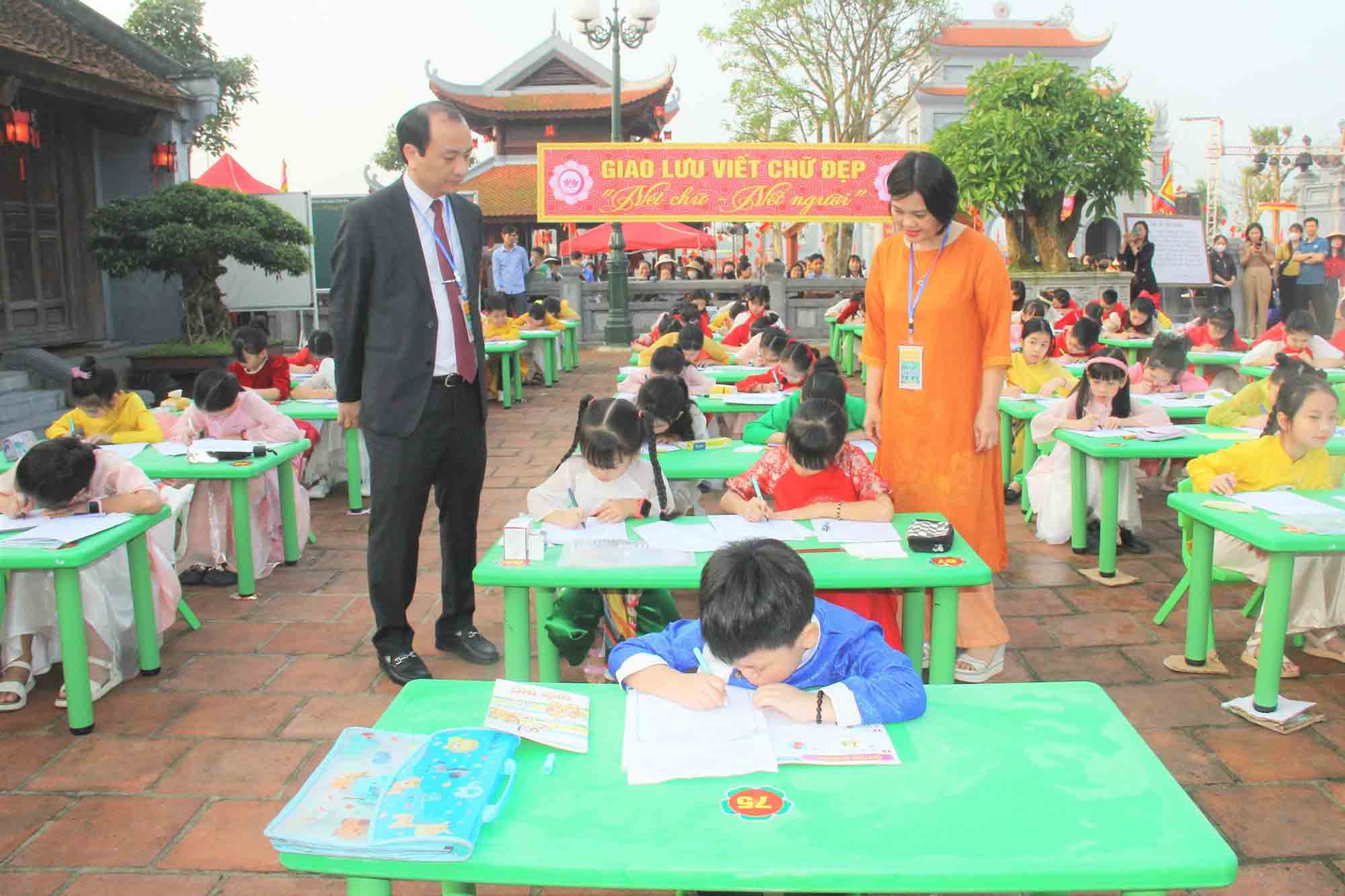 Các em học sinh thi viết chữ đẹp tại lễ hội Văn miếu Hà Tĩnh. Ảnh: Trần Tuấn.