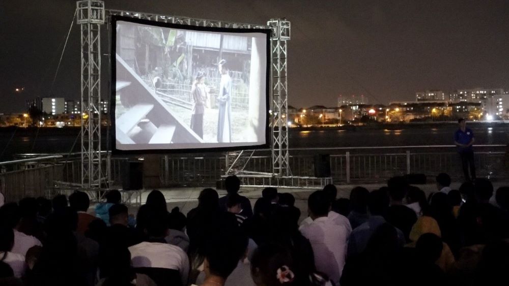 Người trẻ Đà Nẵng ngồi bệt, đứng để coi phim Thầu Chín ở Xiêm được chiếu ngoài trời. Ảnh: Trần Thi