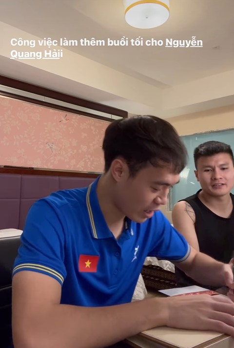 Tiền đạo Văn Toàn (trái) viết thiệp cưới cho tiền vệ Quang Hải. Ảnh cắt từ video