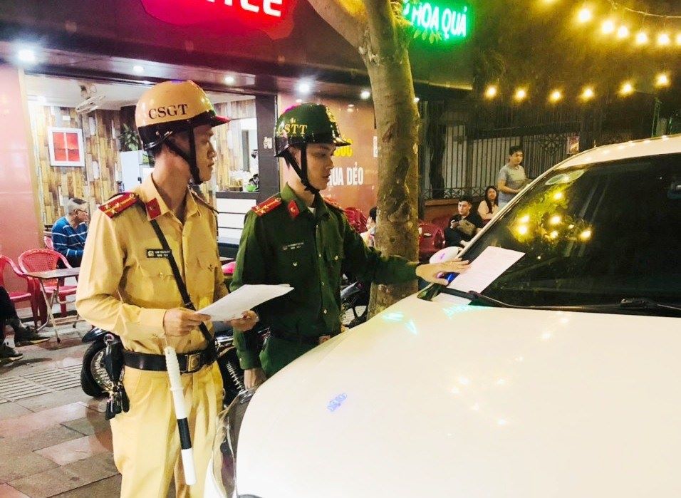 Đội Cảnh sát giao thông trật tự - Công an quận Hồng Bàng xử lý xe ô tô đỗ trên vỉa hè. Ảnh: Công an Hải Phòng