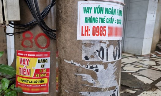 Tờ rơi, áp phích về các dịch vụ cho vay nhanh không cần thế chấp, giải ngân siêu tốc kèm theo số điện thoại liên hệ tại đường Đặng Thai Mai (TP Vinh, Nghệ An). 
Ảnh: Quang Đại