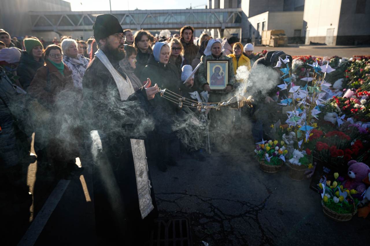 Một linh mục tiến hành buổi lễ tại đài tưởng niệm tạm thời trước Crocus City Hall ngày 25.3.2024. Ảnh: AP