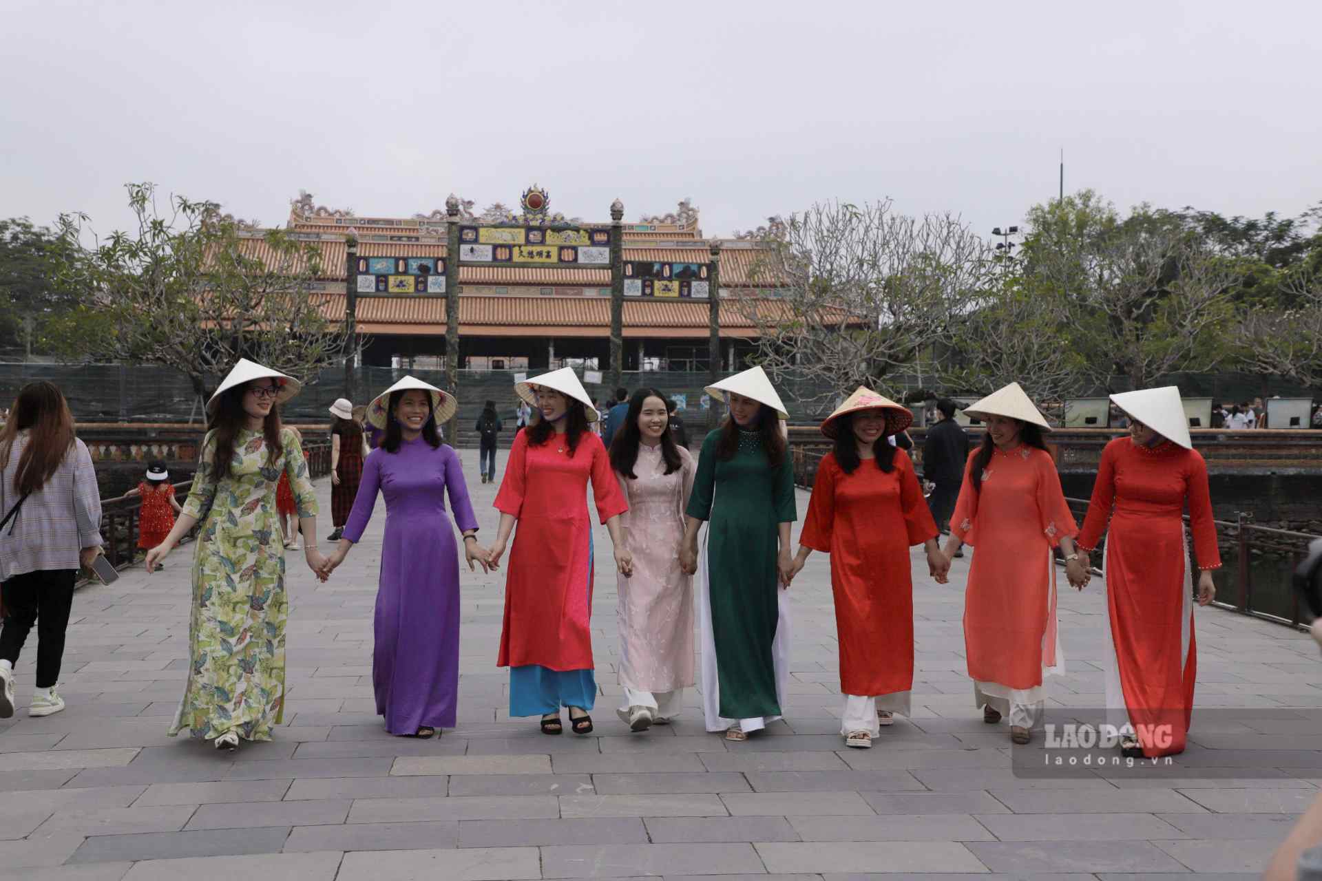 Phụ nữ Việt Nam trong tà áo dài truyền thống khoe dáng cạnh di tích Huế. 