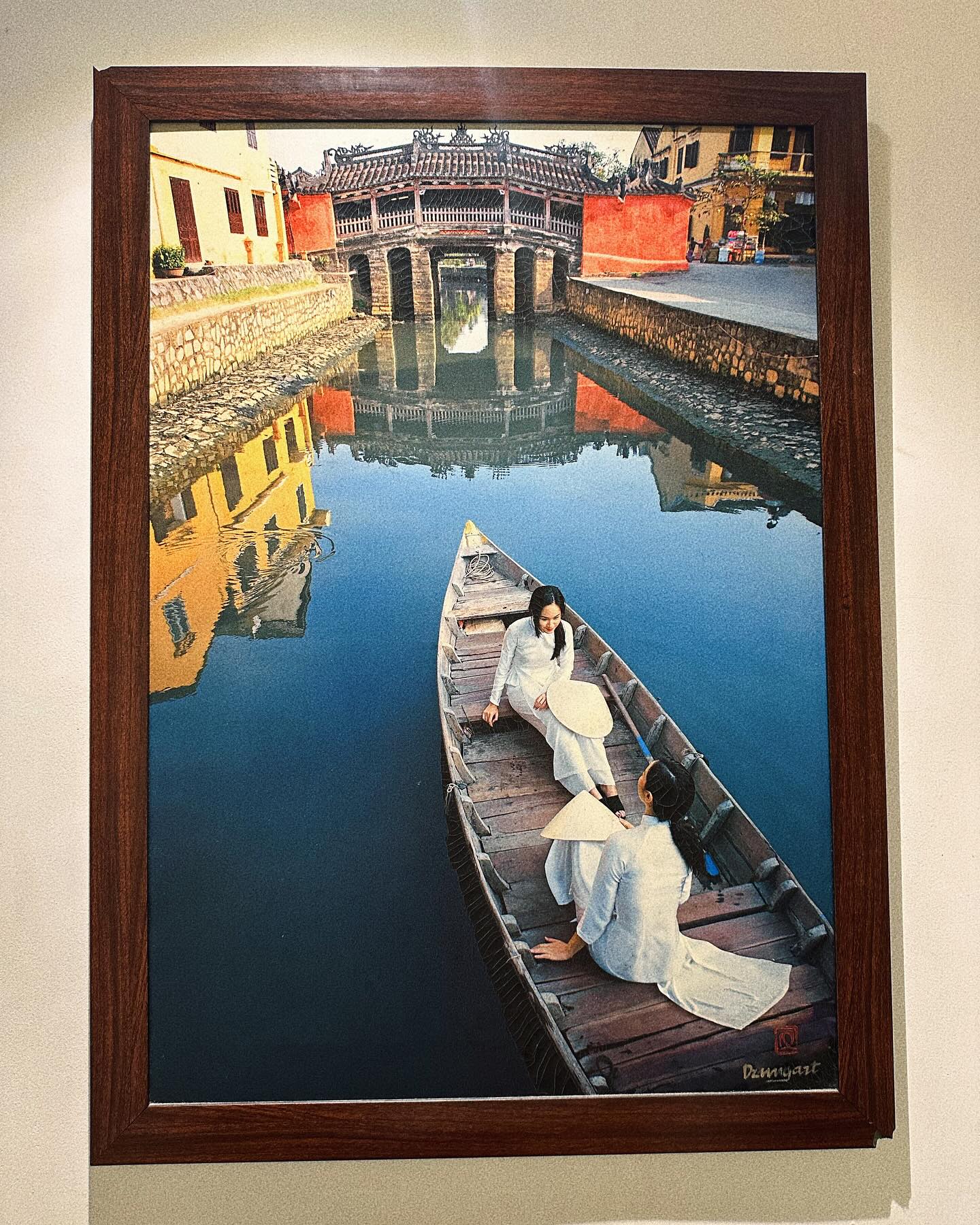 Người đẹp chụp lại bức ảnh treo trên quán, trên ảnh vẽ hình những cô gái mặc áo dài trắng, ngồi thuyền trên sông Hoài ở Hội An.