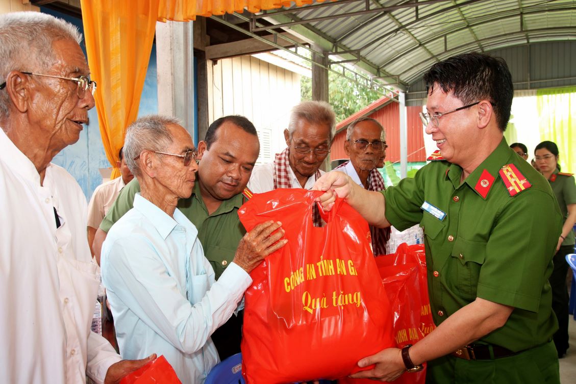 Đại tá Nguyễn Thế Hải - Phó Giám đốc Công an tỉnh An Giang trao quà cho người dân Campuchia sau khi khám bệnh, cấp thuốc miễn phí. Ảnh: Nghiêm Túc