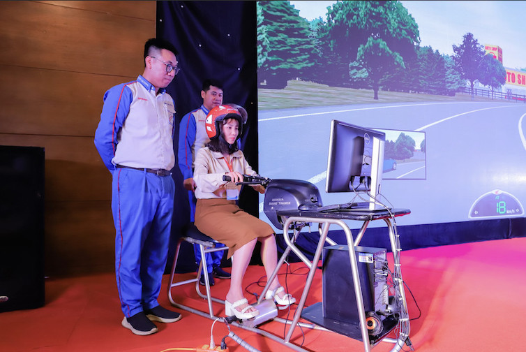 Giáo viên trải nghiệm các trình huống mô phỏng trên máy tập lái xe cùng Hướng dẫn viên của Honda Việt Nam. Ảnh: HVN