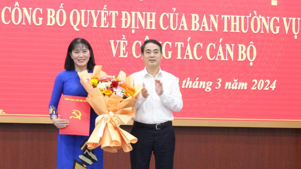 Bí thư Tỉnh ủy Hậu Giang Nghiêm Xuân Thành trao quyết định và tặng hoa chúc mừng bà Hồ Thu Ánh. Ảnh: Tạ Quang 