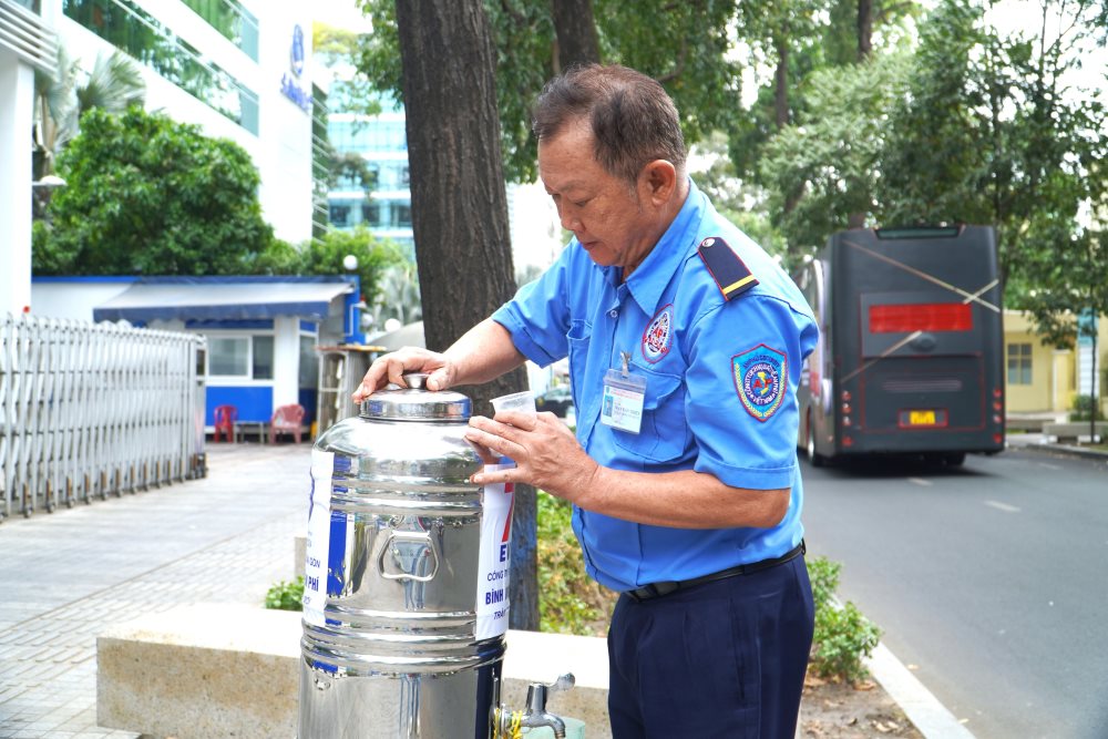 Ông Huỳnh Văn Thiện (bảo vệ công ty trên đường Võ Văn Tần, Quận 3) mỗi ngày đều trông coi châm nước vào bình phục vụ cho người đi đường.