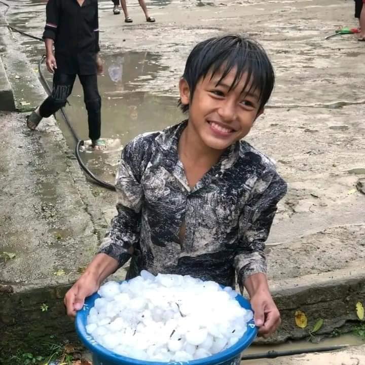 Trẻ em nhặt đá từ trận mưa đem về chơi. Ảnh: Anh Tuấn