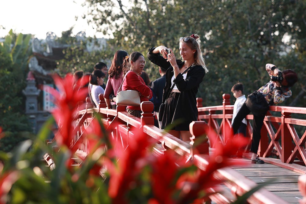 Khách du lịch chụp ảnh lưu niệm trên cầu Thê Húc, hồ Hoàn Kiếm, Hà Nội. Ảnh: Hải Nguyễn