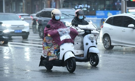 Người dân đi lại trong mưa tuyết vào ngày 20.2.2024 ở Phụ Dương, tỉnh An Huy, Trung Quốc. Ảnh: VCG