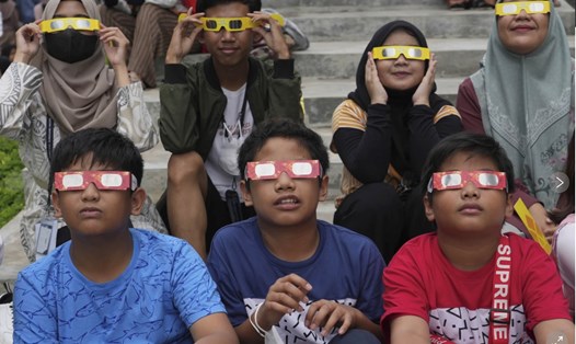 Những người trẻ đeo kính chuyên dụng khi ngắm nhật thực ở Indonesia năm 2023. Ảnh: AP 
