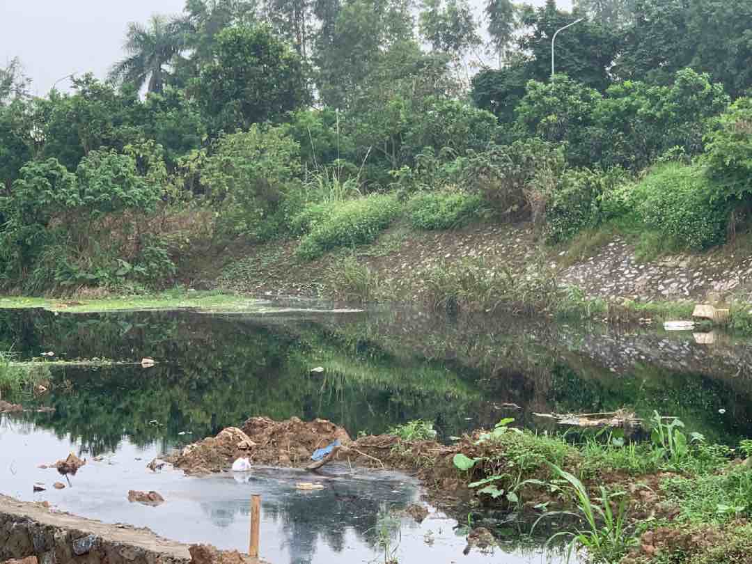 Dòng sông Cầu Bây chảy qua huyện Gia Lâm bị ô nhiễm bởi rác thải và nước thải chưa qua xử lý. Ảnh: Nhật Minh