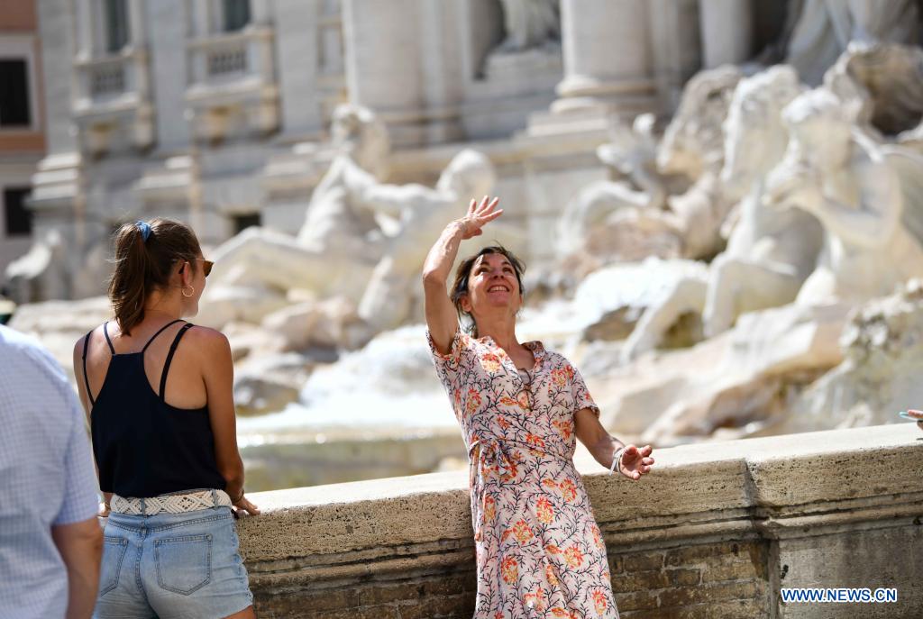 Một khách du lịch ném đồng xu vào lưu vực Fontana di Trevi ở Rome, Italy, vào năm 2021. Ảnh: Xinhua