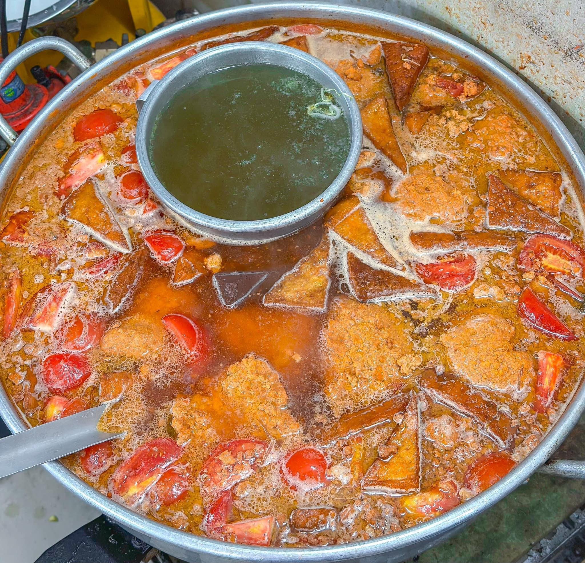 Nồi nước lèo béo ngậy, vàng ươm nhờ dầu điều và cà chua tại bún riêu Út Hồng. Ảnh: Foody