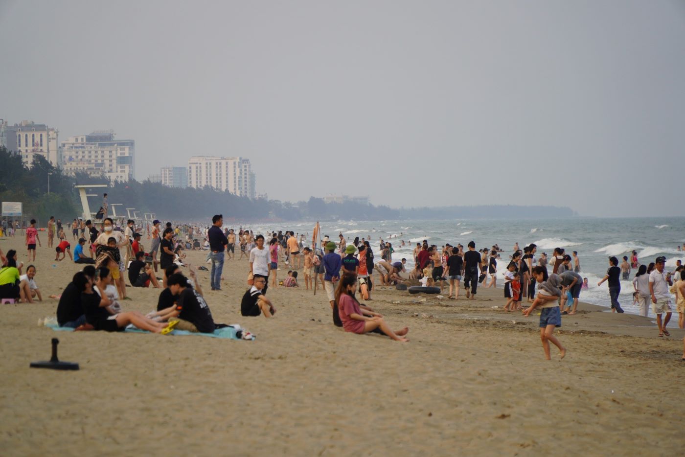 Rất đông người dân, du khách ngồi hóng gió trên bãi biển. Ảnh: Quách Du