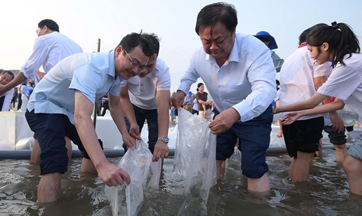 Bộ trưởng Bộ NN&PTNT Lê Minh Hoan thả cá giống. Ảnh: Bộ NN&PTNT