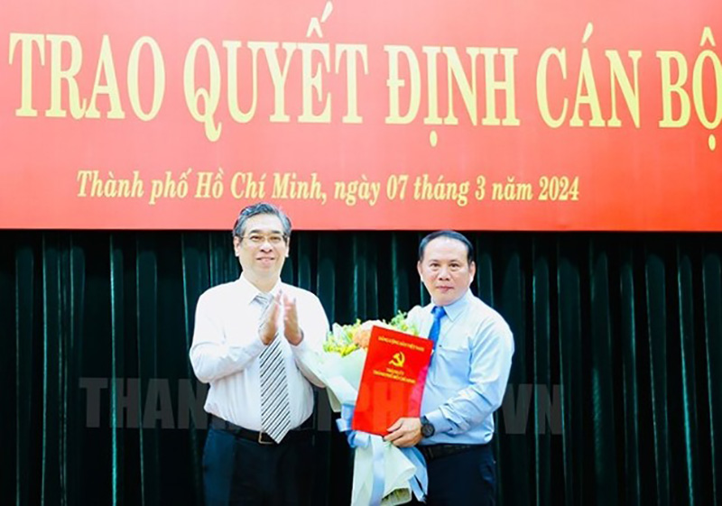 Phó Bí thư Thành ủy TPHCM Nguyễn Phước Lộc trao quyết định và hoa chúc mừng ông Lâm Hùng Tấn. Ảnh: Thành ủy TPHCM  