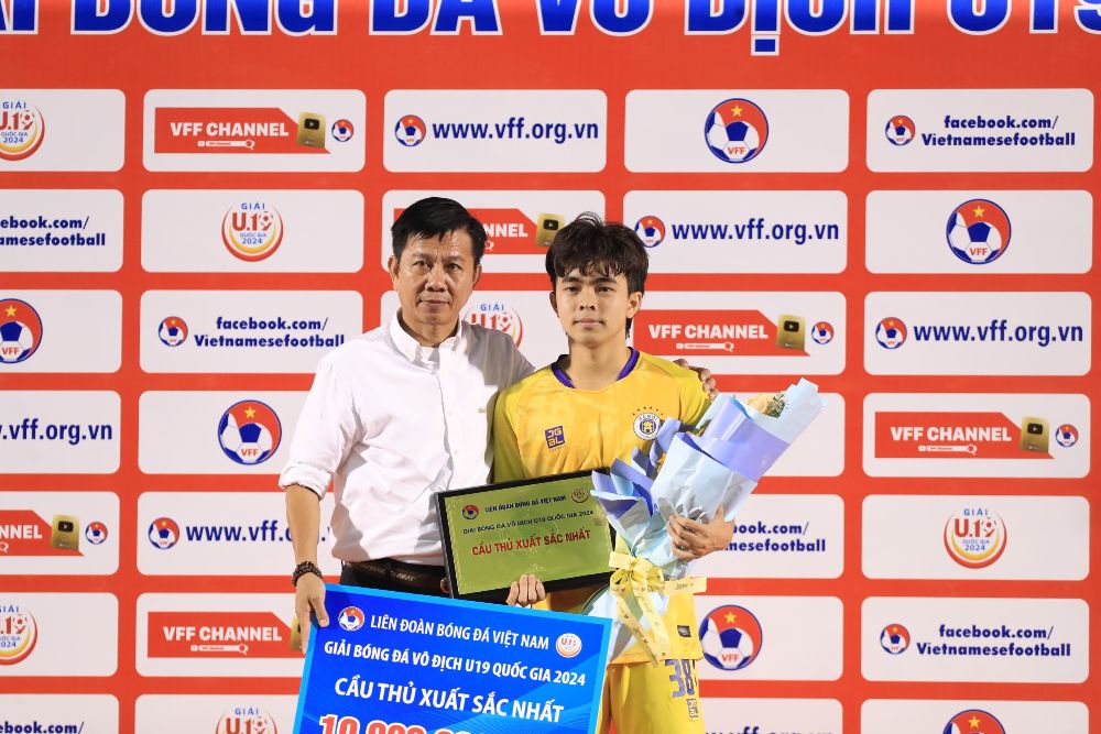 Huấn luyện viên Hoàng Anh Tuấn trao bảng danh vị và phần thưởng “Cầu thủ xuất sắc nhất” cho Dương Đình Nguyên của đội U19 Hà Nội.