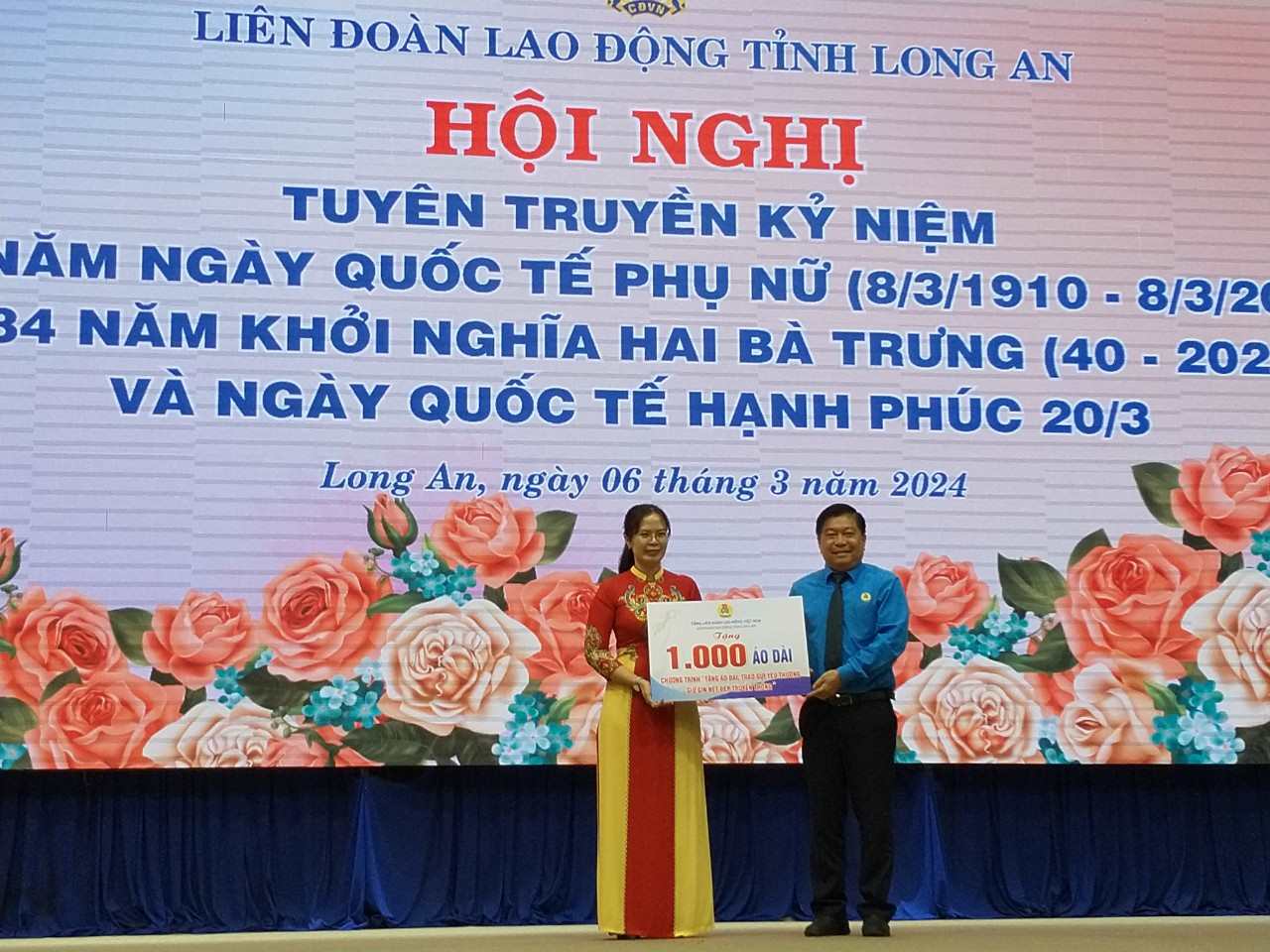Chủ tịch LĐLĐ tỉnh Long An trao tượng trưng 1.000 chiếc áo dài của Tổng LĐLĐ Việt Nam cho người lao động nữ tỉnh Long An. Ảnh: Kỳ Quan