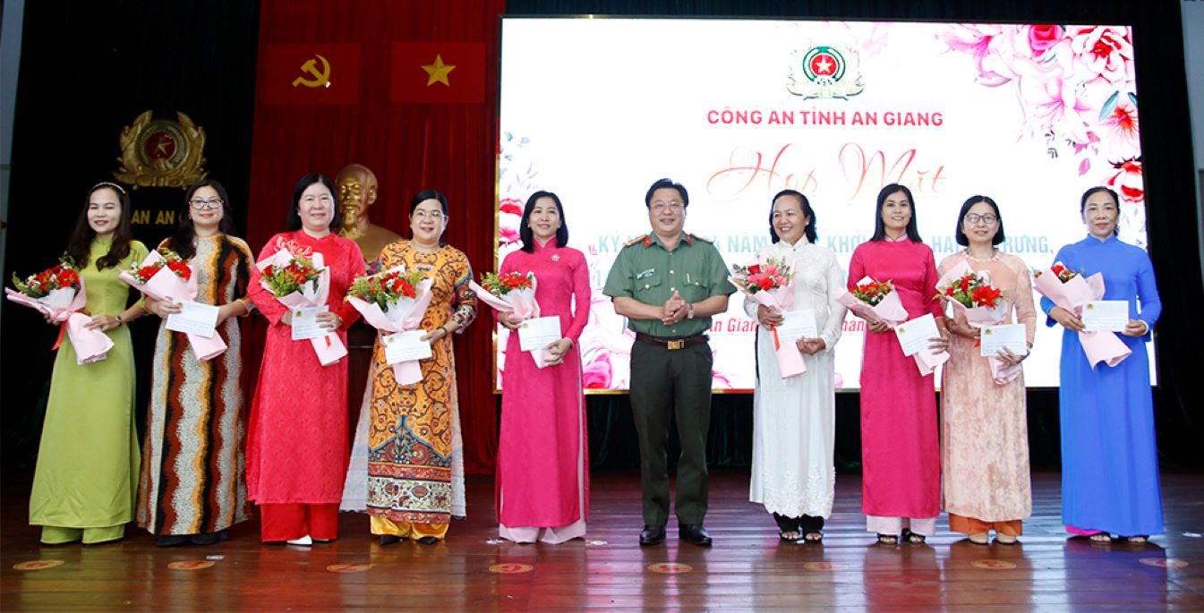 Đại tá Lâm Phước Nguyên - Bí thư Đảng ủy, Giám đốc Công an tỉnh An Giang tặng hoa, chúc mừng các đồng chí nữ là lãnh đạo các phòng nghiệp vụ Công an tỉnh. Ảnh: Vũ Tiến
