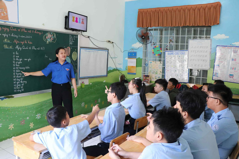Cô Lê Hoàng Trân hướng dẫn học sinh khối 2 và 3 học ngôn ngữ ký hiệu. Ảnh: Hữu Long 