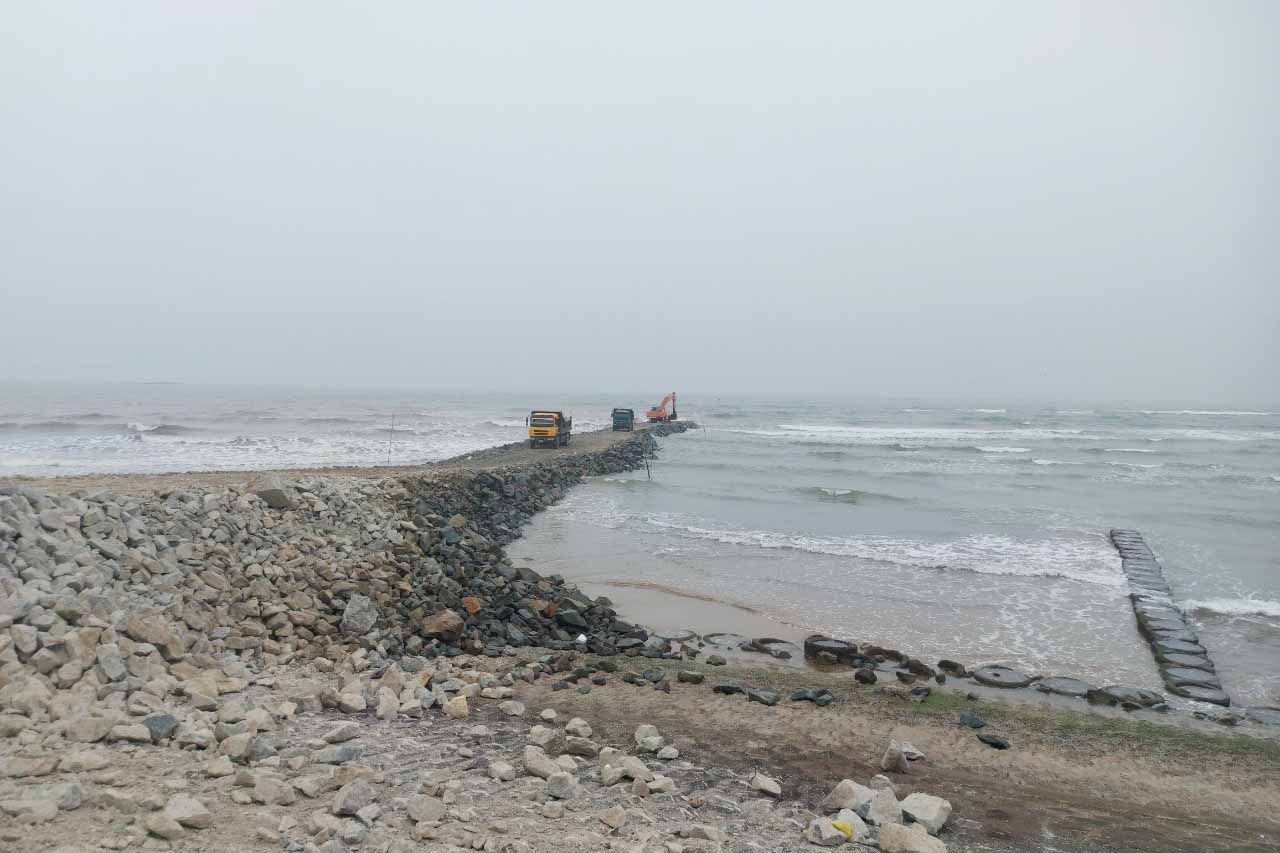 Đang thi công hạng mục đê chắn cát thuộc Dự án xây dựng cảng cá Cửa Nhượng để ngăn cát bồi lắng luồng lạch vào cảng. Ảnh: Trần Tuấn.