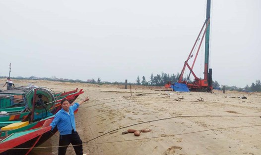 Ngư dân Hưng chỉ tay về dự án cảng cá Cửa Nhượng đang thi công với mong muốn dự án sớm hoàn thành để ngư dân thuận lợi làm nghề biển. Ảnh: Trần Tuấn.