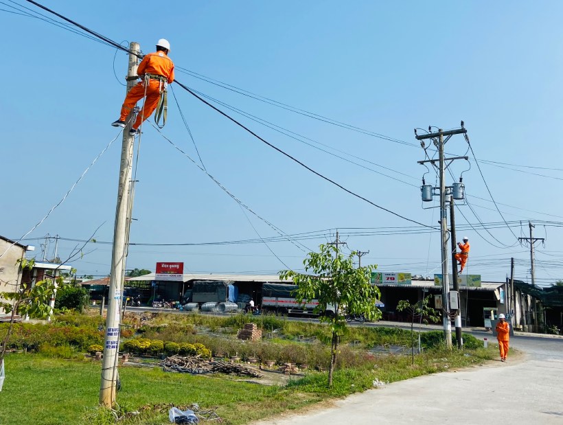 Công nhân Điện lực Chợ Lách thi công công trình gắn đèn trên tuyến đường vào trường THPT Võ Văn Kiệt. Ảnh: Thành Nhân