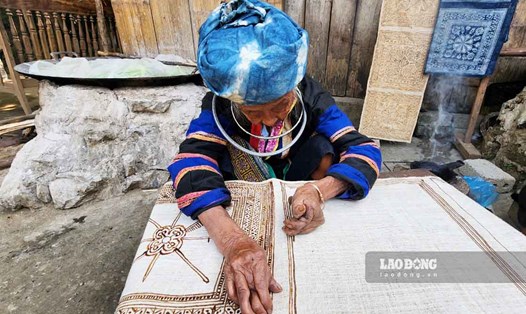 Nghệ nhân hơn 100 tuổi người Mông ở Lùng Tám vẽ sáp ong trên vải lanh.