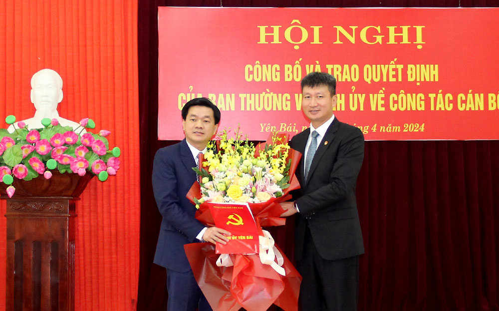 Chủ tịch UBND tỉnh Yên Bái Trần Huy Tuấn trao quyết định và tặng hoa chúc mừng tân Phó Trưởng Ban Nội chính Tỉnh ủy. Ảnh: Cổng thông tin Yên Bái 