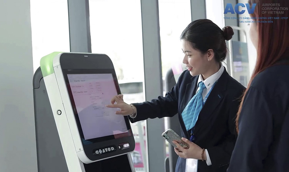 Nhân viên Sân bay Điện Biên hướng dẫn khách làm thủ tục điện tử. Ảnh: Khánh Hòa