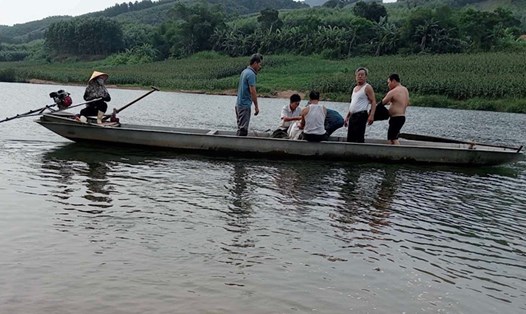 Gia đình dùng thuyền đưa thi thể nạn nhân đuối nước vào bờ. Ảnh: Nguyễn Hồ.