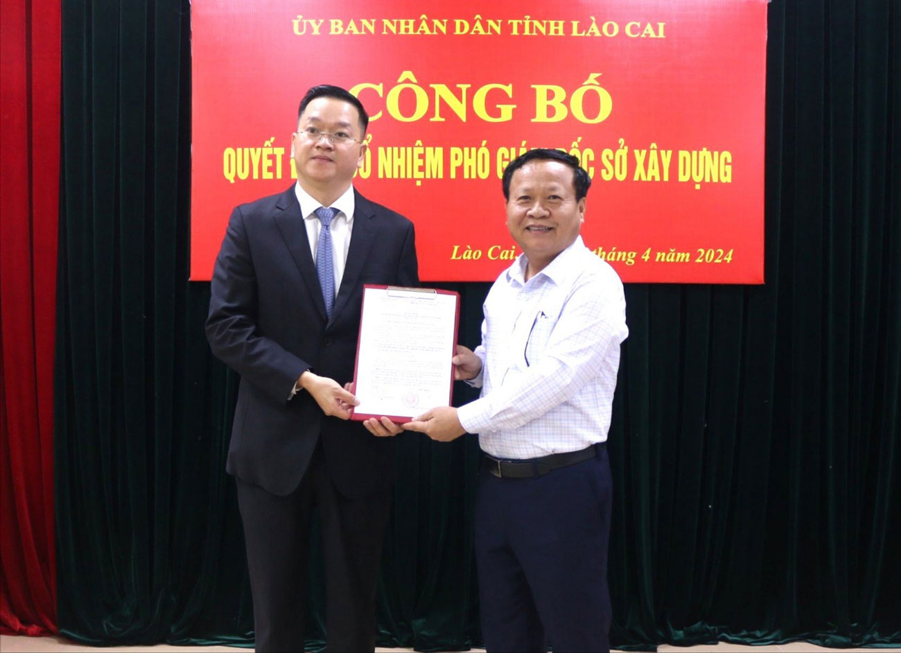 Ông Nguyễn Trọng Hài, Phó Chủ tịch UBND tỉnh Lào Cai trao quyết định và tặng hoa chúc mừng ông Nguyễn Quang Bình. Ảnh: Lê Nam