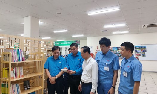 Cán bộ Công đoàn Thành phố và lãnh đạo doanh nghiệp trao đổi về các đầu sách có trên giá sách tại Điểm sinh hoạt văn hóa Công nhân Công ty TNHH SWCC Showa Việt Nam. Ảnh: CĐKCN