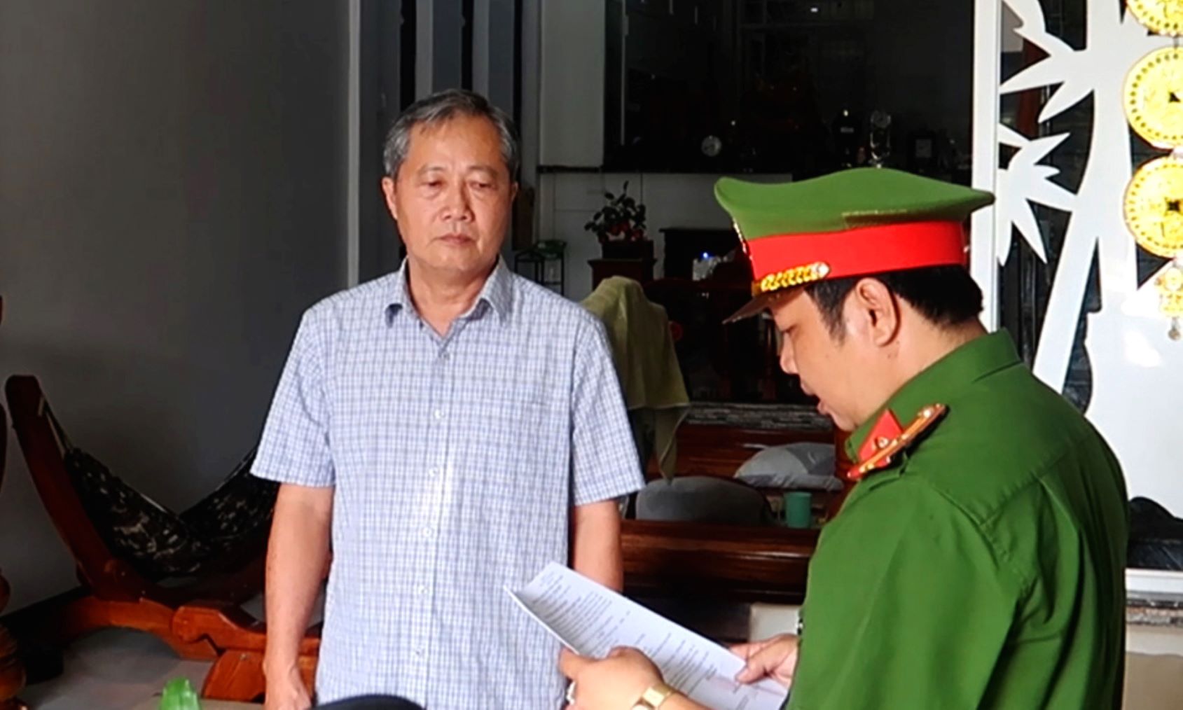 Huỳnh Lê Phong - nguyên Trưởng Phòng Tài nguyên và môi trường TP Long Xuyên nghe cơ quan điều tra đọc lệnh khởi tố, bắt giam. Ảnh: Công an cung cấp
