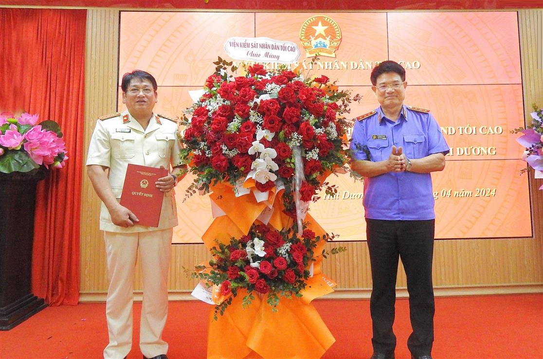 Phó Viện trưởng Thường trực VKSND tối cao Nguyễn Huy Tiến  trao quyết định bổ nhiệm và tặng hoa chúc mừng ông Nguyễn Mạnh Vỹ. Ảnh: Cổng TTĐT Hải Dương
