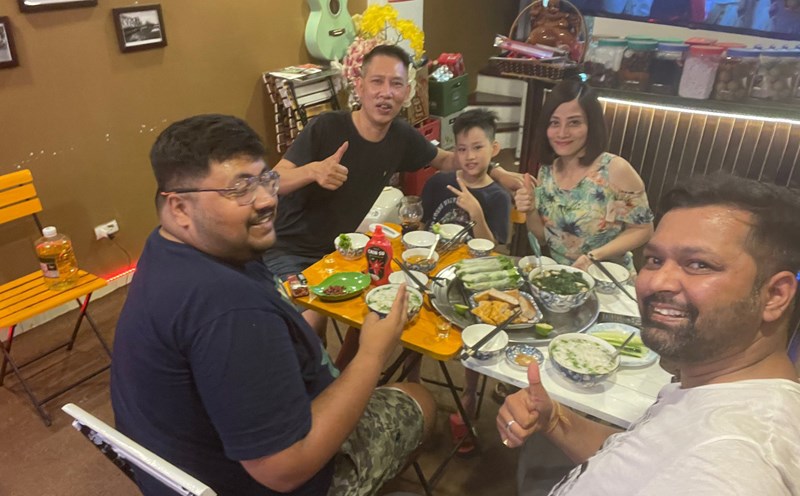 Hai du khách Ấn Độ ăn cơm cùng người địa phương trong chuyến du lịch Hà Nội, Việt Nam. Ảnh: Nhân vật cung cấp