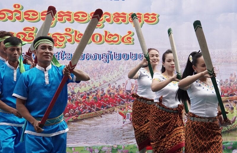 Trên bờ, đội văn nghệ Khmer biểu diễn phục vụ cho khách đến xem đồng thời cổ vũ cho các đội đua.