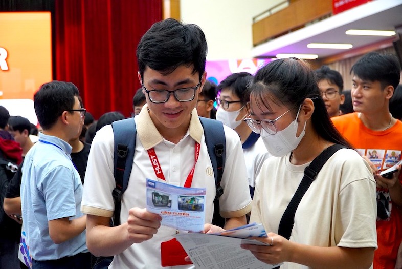 Nguyễn Văn Nhất, sinh viên năm cuối Khoa Cơ điện tử (bên trái) tìm hiểu thông tin vị trí việc làm, mức thu nhập và chính sách đãi ngộ. Ảnh: Vân Trang 