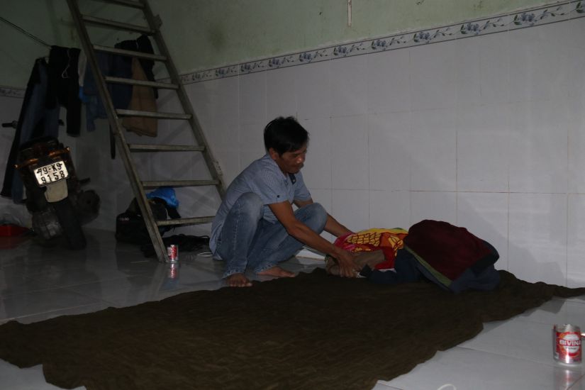 Căn phòng trọ của anh Võ Văn Dư cùng 3 đồng nghiệp có khu bếp tạm bợ sát nhà vệ sinh, chỗ ngủ là nền nhà với chiếc chăn vừa trải vừa đắp. Ảnh: Phương Linh