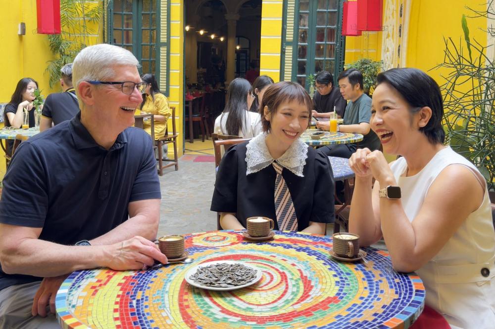 Tim Cook ngồi thưởng thức cà phê trứng cùng ca sĩ Mỹ Linh và Mỹ Anh. Ảnh:  X