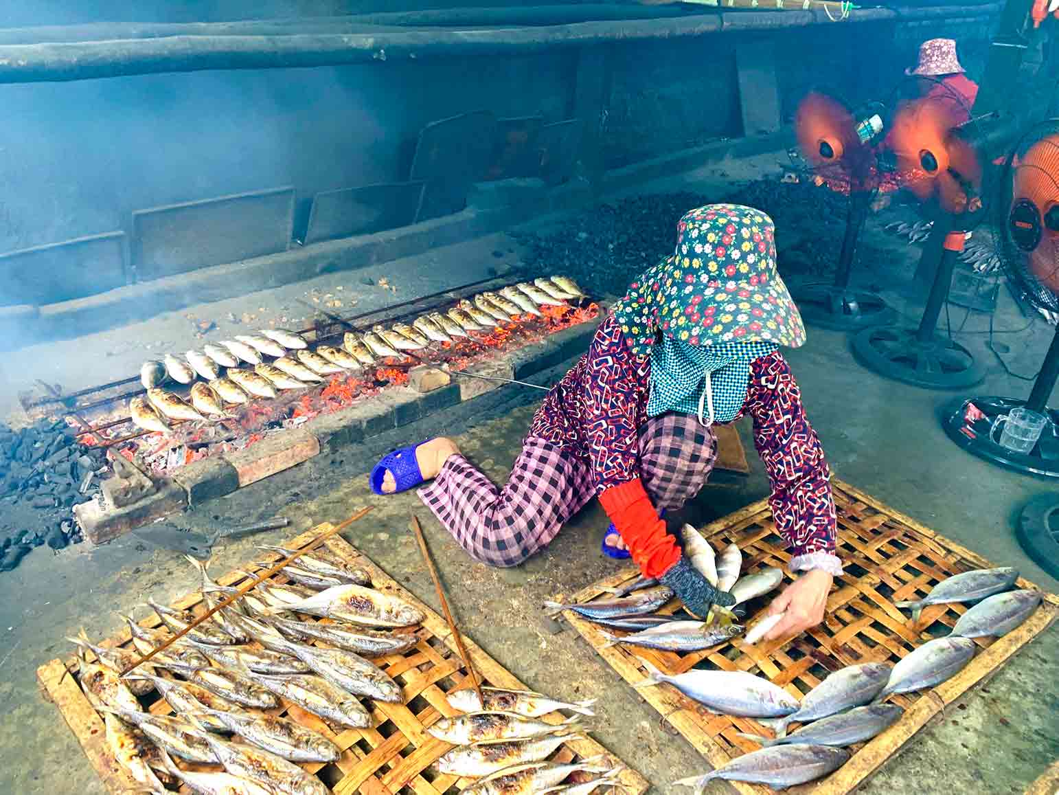 Nhiệt độ ngoài trời lên đến gần 40 độ C, các bà các chị vẫn phải ngồi bên bếp than nóng rực để nướng cá. Mỗi ngày, người nướng cá được chủ lò trả từ 150.000-250.000 đồng, thu nhập hàng tháng trên 5 triệu đồng/người